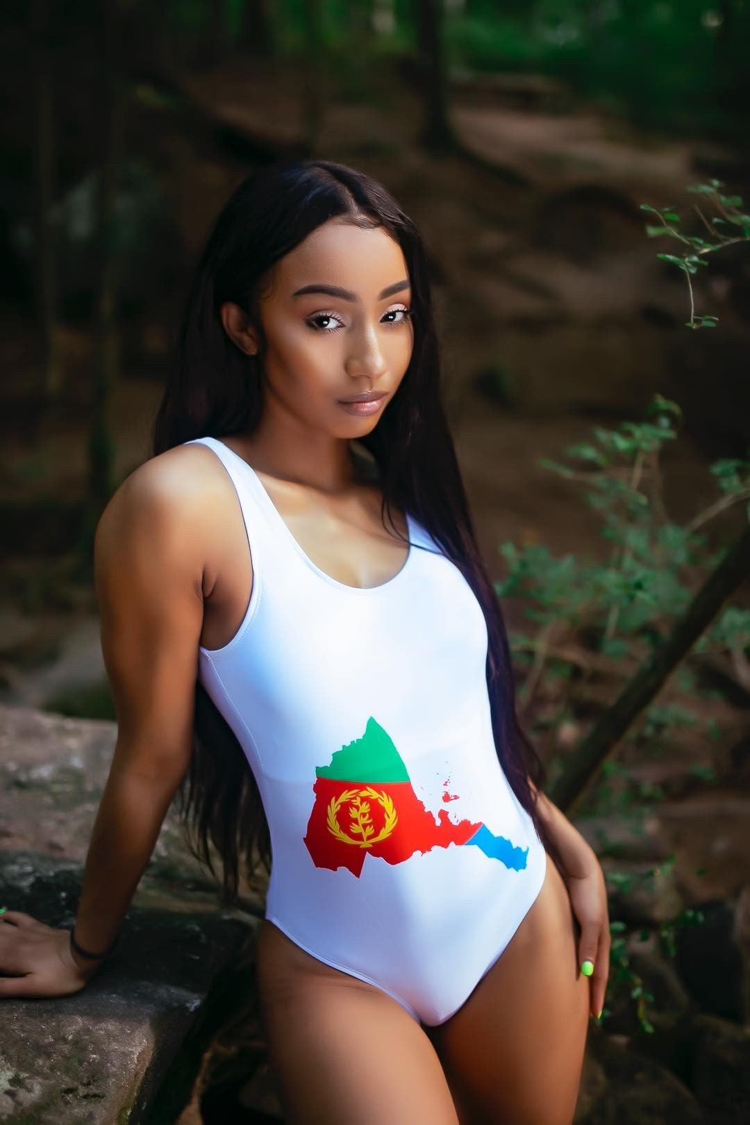 Front view of women's one-piece swimsuit in white with map of  Eritrea worn by Rubi Rose