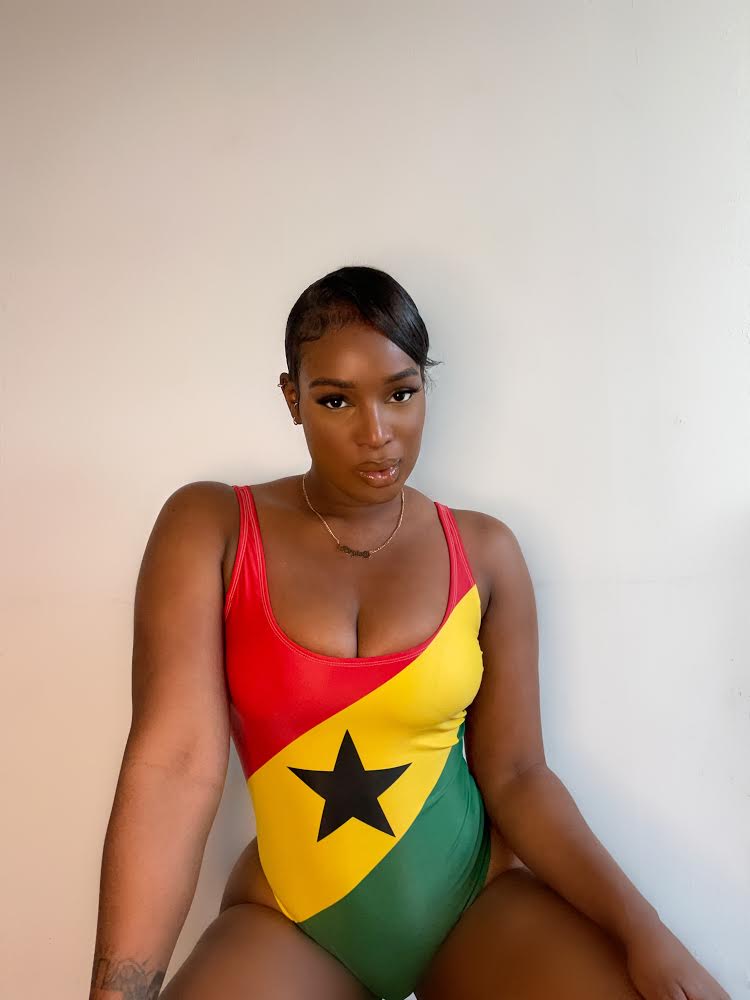 Front view of women's one-piece swimsuit inspired by the Ghana flag, worn by Ghanaian artist Nana Fofie.